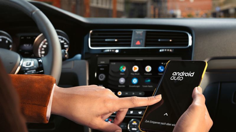 A person selecting Android Auto app on their smartphone