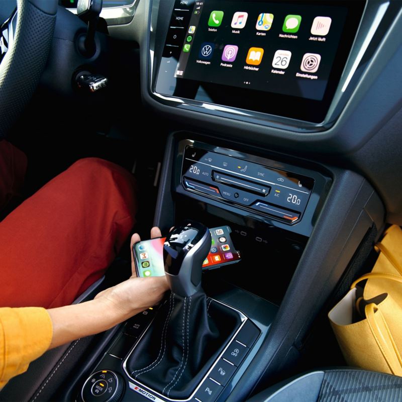 A driver looking at their mobile phone inside their car