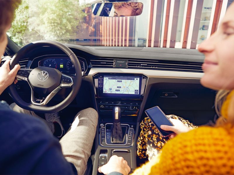 A couple sitting in the front seats of a VW vehicle