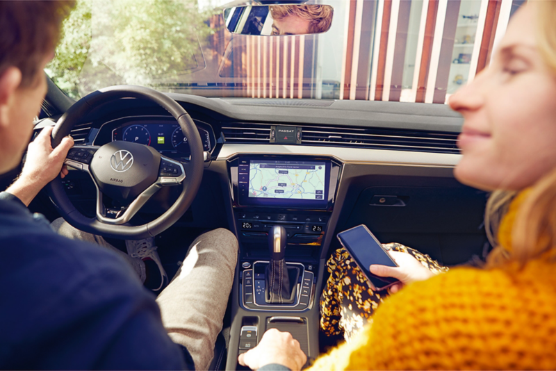 A couple sitting in the front seats of a VW vehicle