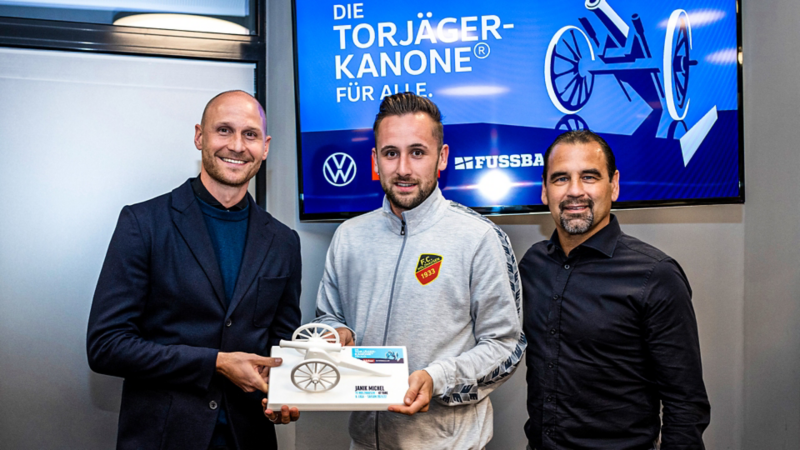 Ein Gruppenfoto von Benedikt Höwedes, Ulf Kirsten und einem Torjägerkanonen-Gewinner.