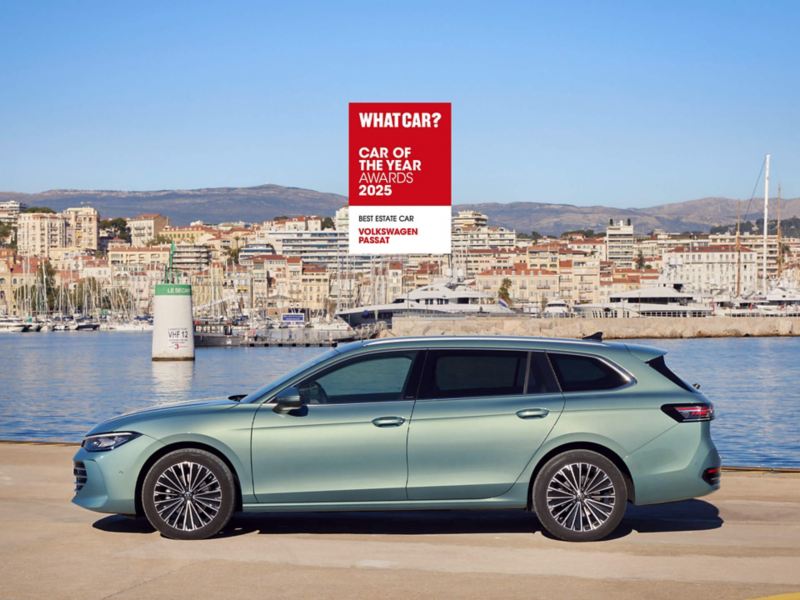 A bluish green Passat parked by a harbour