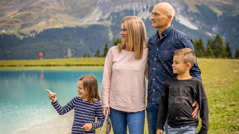 Eine Familie mit Hund beim See