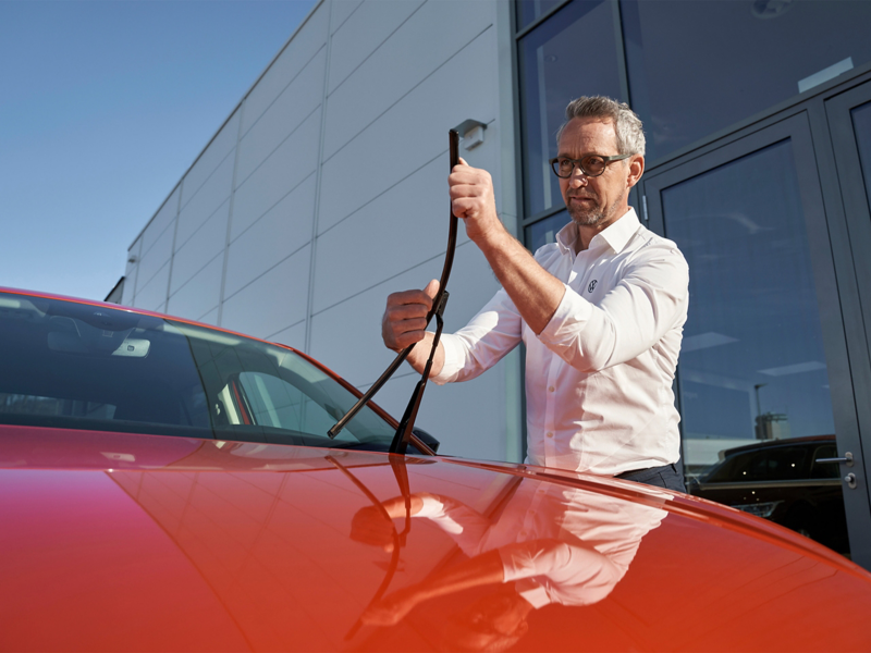 Man adjusting Volkswagen Windscreen wipers on Volkswagen