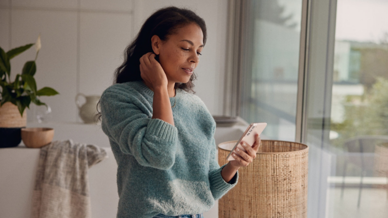 A woman looking at ways to save on her smartphone