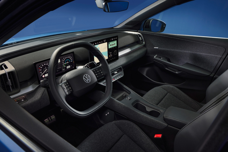 Volkswagen electric car interior showing the steering wheel, dashboard, and central touchscreen display.