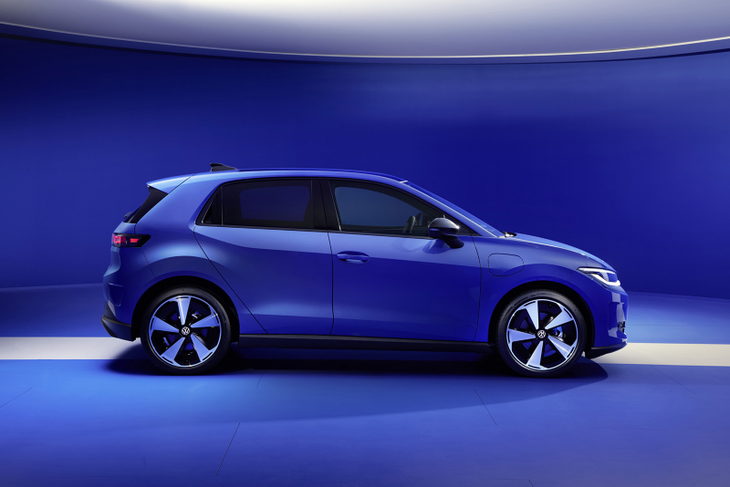 Side profile view of a blue Volkswagen ID. Polo electric hatchback parked in a blue studio, showcasing its aerodynamic design and modern five-spoke wheels.