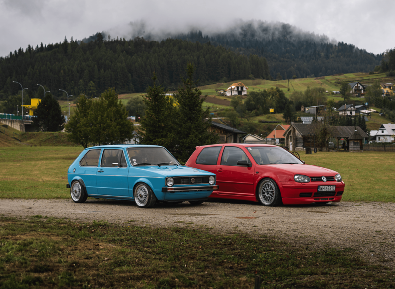 Dwa Volkswageny na tle górskiego krajobrazu.