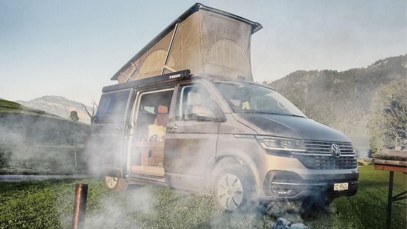 EIn VW Camping Bus steht neben einem Feuer