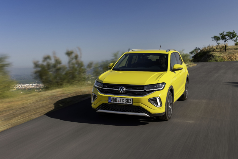 Żółty SUV Volkswagen T-Cross jadący górską drogą poza miastem