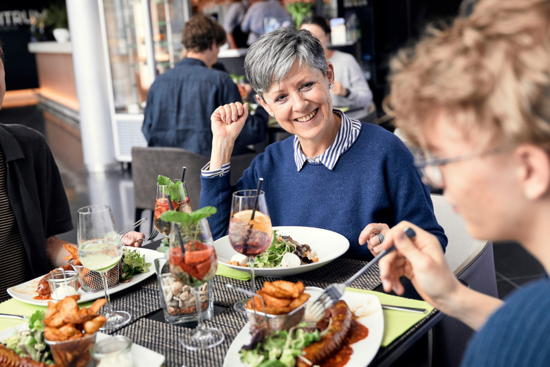 Visitors eating a currywurst in the restaurant of the Transparent Factory