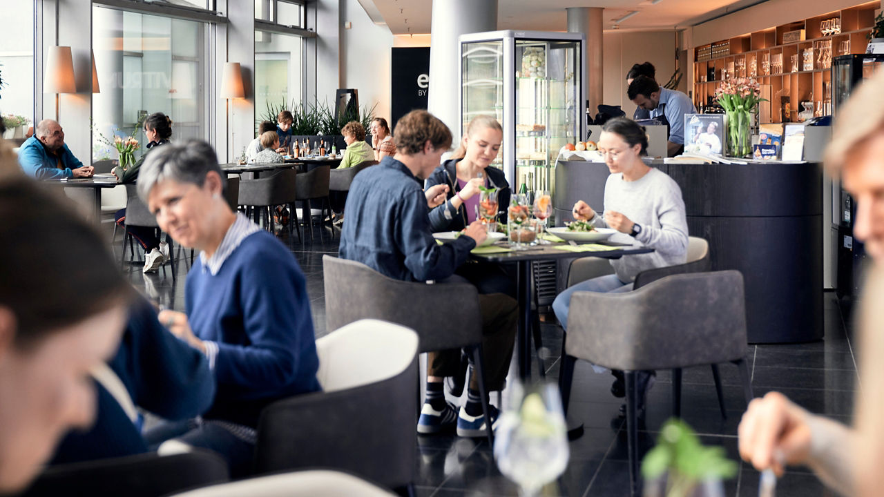 Das Restaurant mit Gästen beim Essen im Hintergrund eine Bar