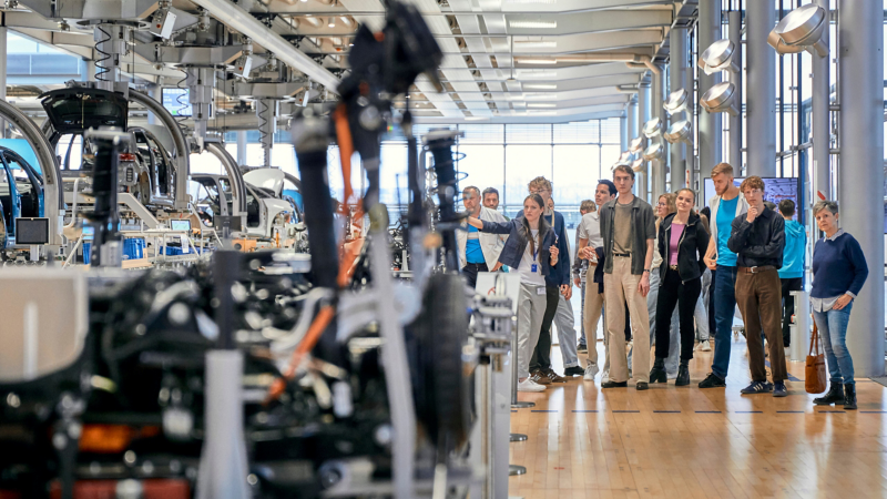 A guide leads a group of visitors through the world of experience of the Transparent Factory in Dresden