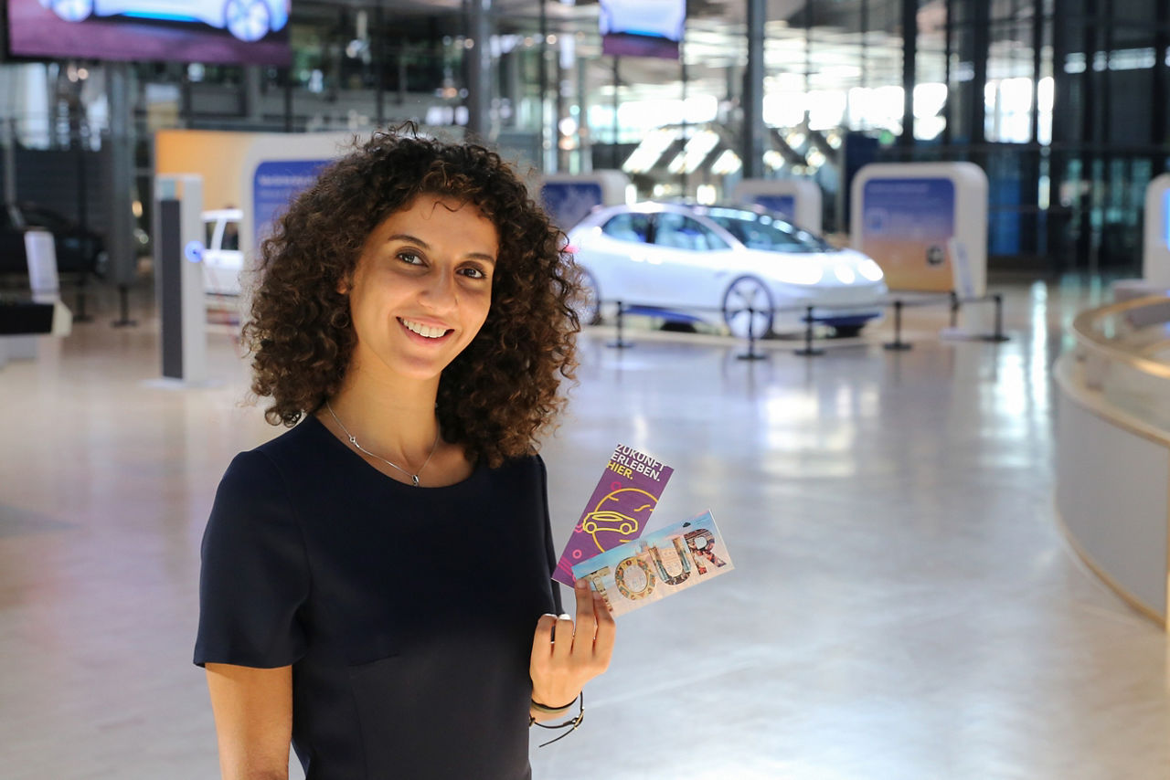Eine Frau präsentiert das Kombi Ticket in der Gläsernen Manufaktur