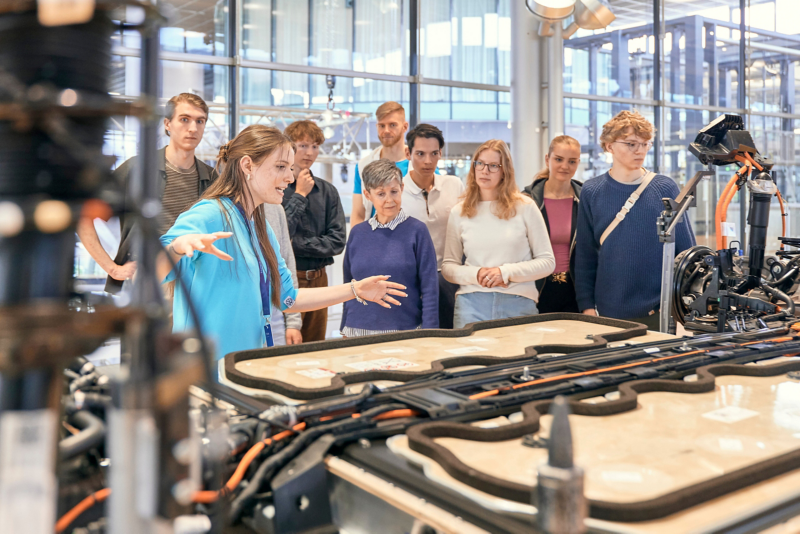 A guide leads a group of visitors through the world of experience of VW's Transparent Factory