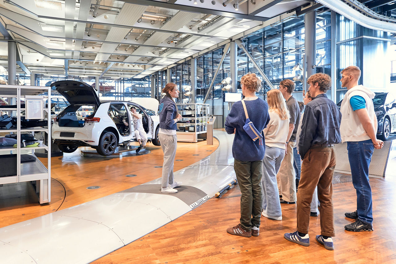 Ein Guide mit Besuchergruppe am Schuppenband der Gläsernen Manufaktur