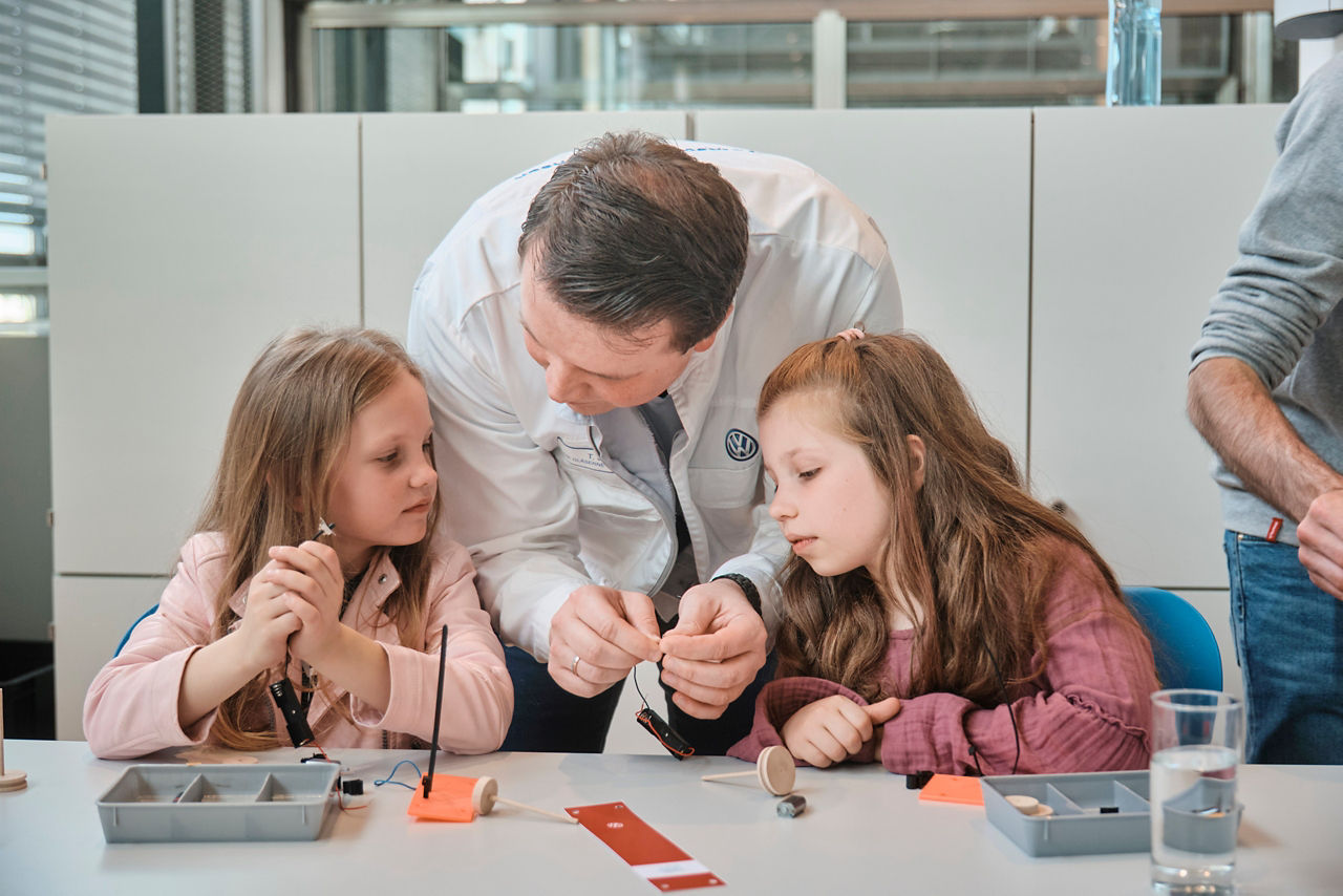 Kinder mit Guide basteln im Schülerlabor der Gläsernen Manufaktur von VW
