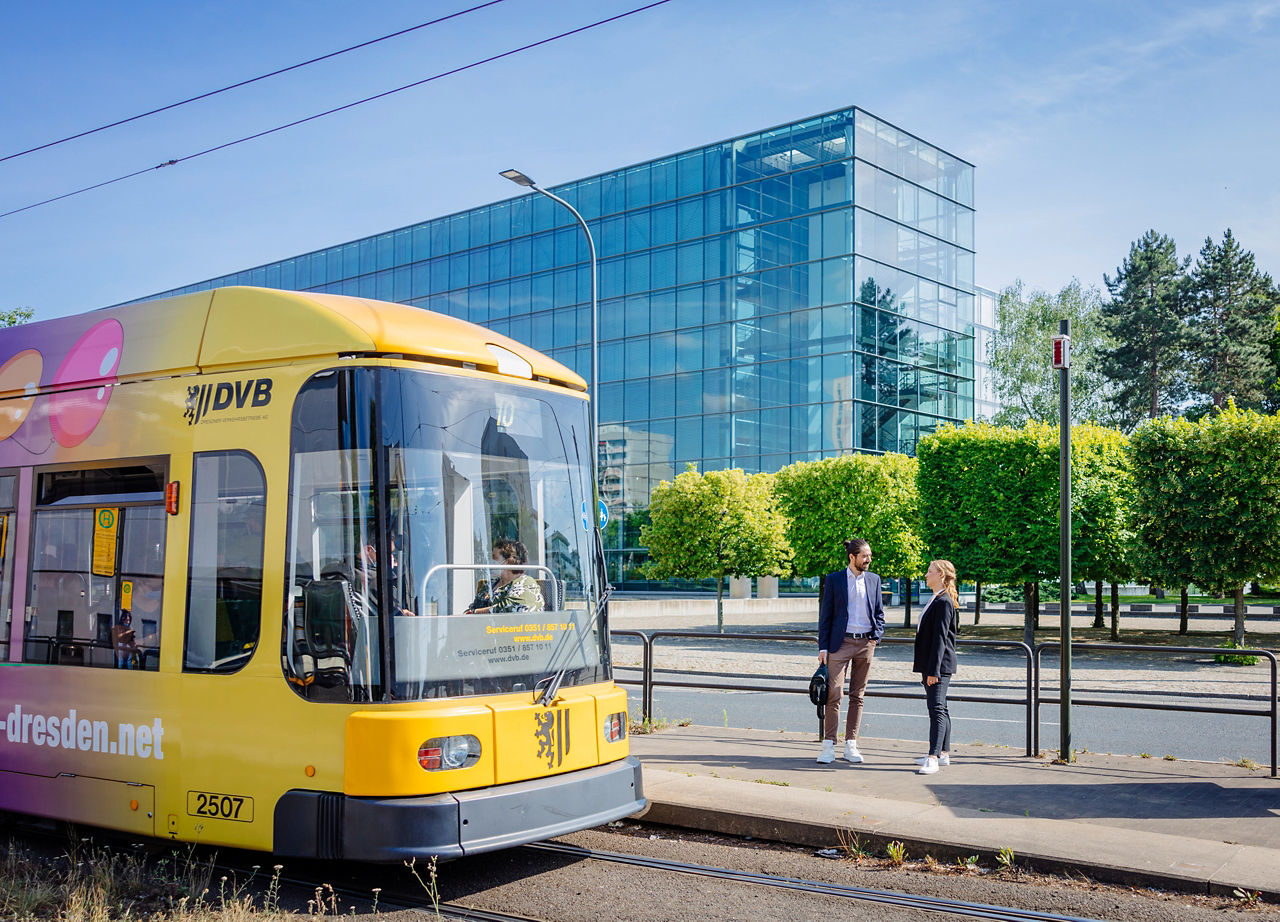 Eine gelbe Straßenbahn an der Haltestelle vor der Gläsernen Manufaktur