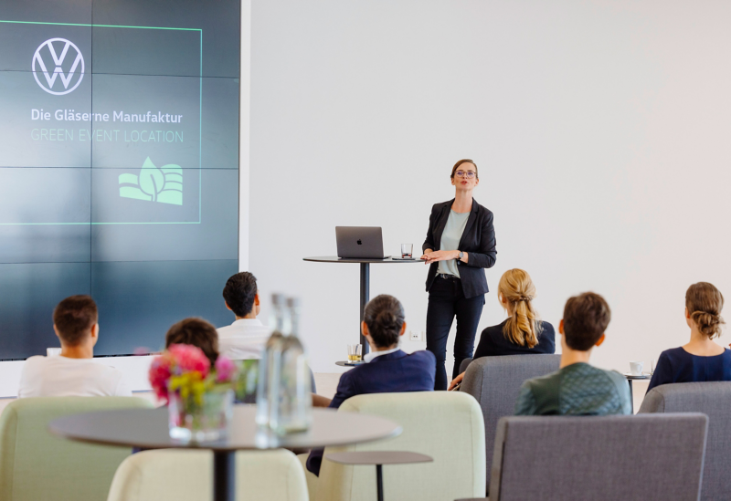 Eine Frau redet zu Gästen während eines Events