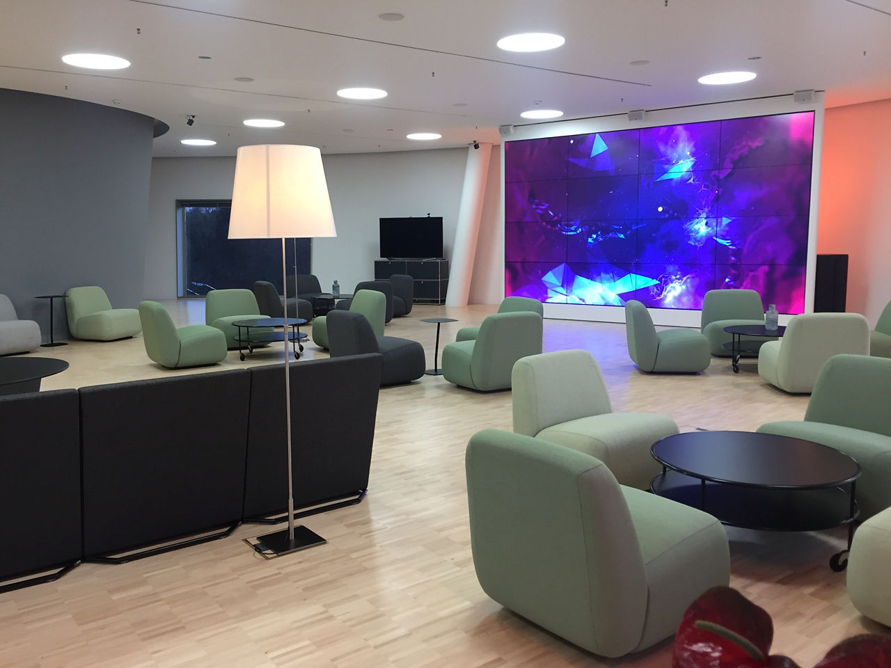 ID Lounge Atelier Innenansicht mit Sitzmöbeln und Videowand
