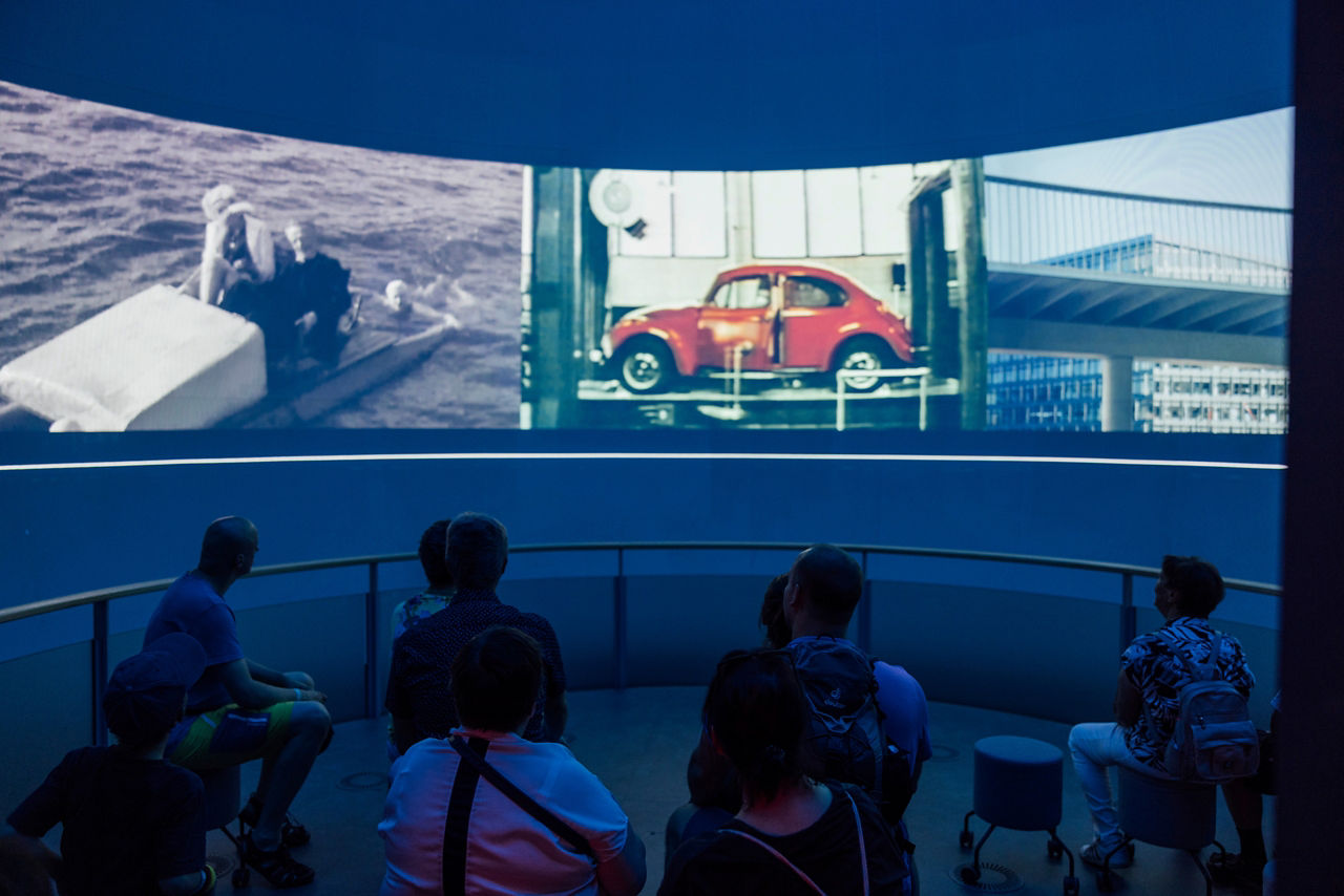 Gäste sitzen Im ID Globe und sehen sich einen Film auf der 270 Grad Leinwand an