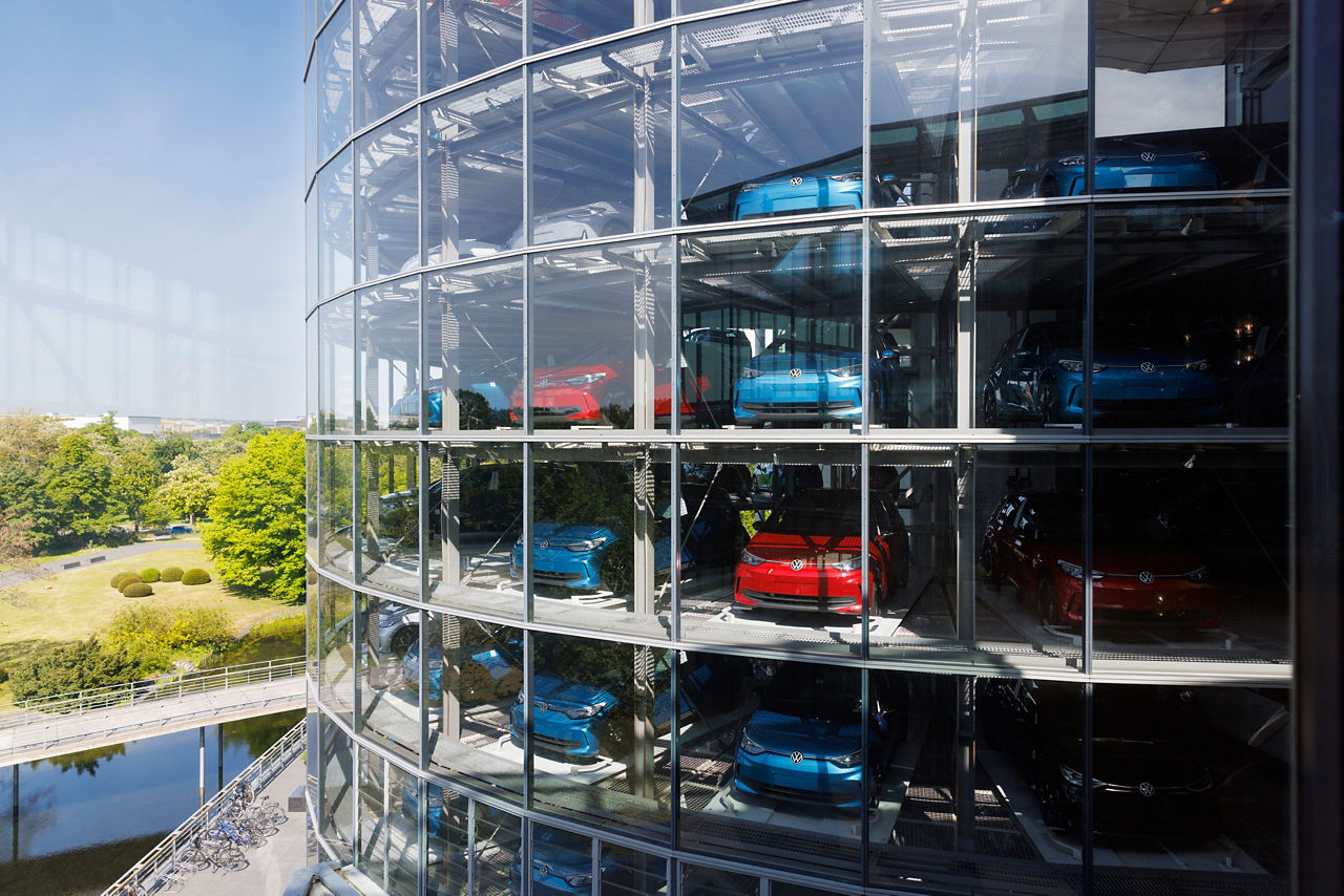 Außenansicht des Fahrzeugturms der Gläsernen Manufaktur mit blauen und roten Fahrzeugen