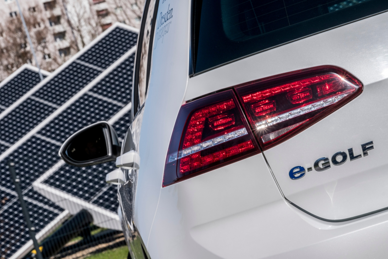 The rear of a VW E Golf in front of a solar panel in VW's Transparent Factory