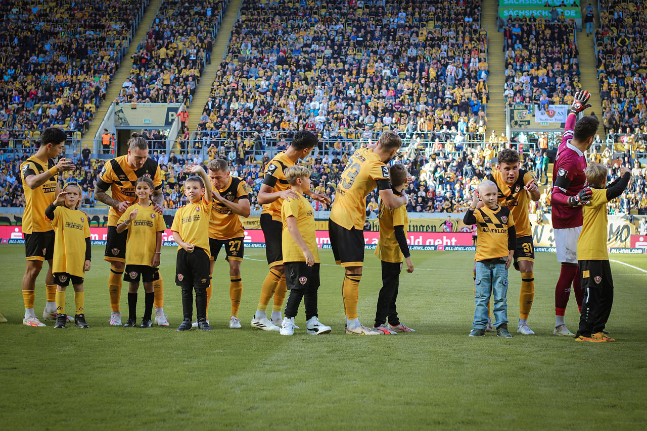 Spieler von Dynamo Dresden im Stadion mit den Einlaufkids