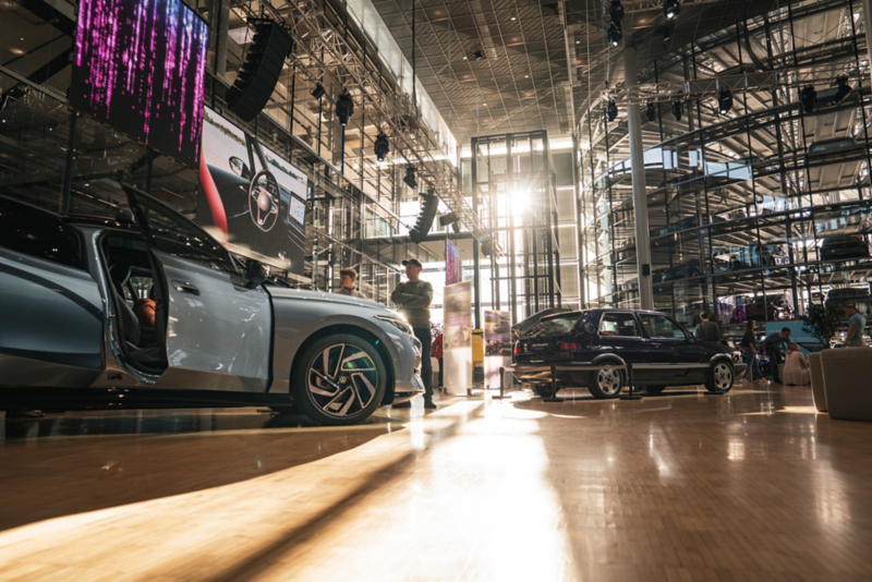 Die Sonne scheint auf die Ausstellungsfläche. Mehrere Personen schauen interessiert auf die ausgestellten Fahrzeuge.