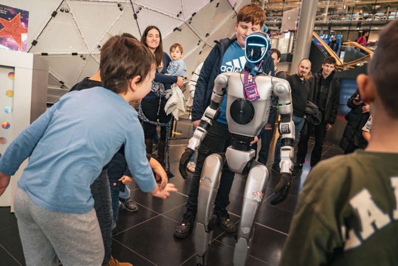 Ein Humanoider Roboter ist umringt von Kindern und Besuchern zu einer Veranstaltung
