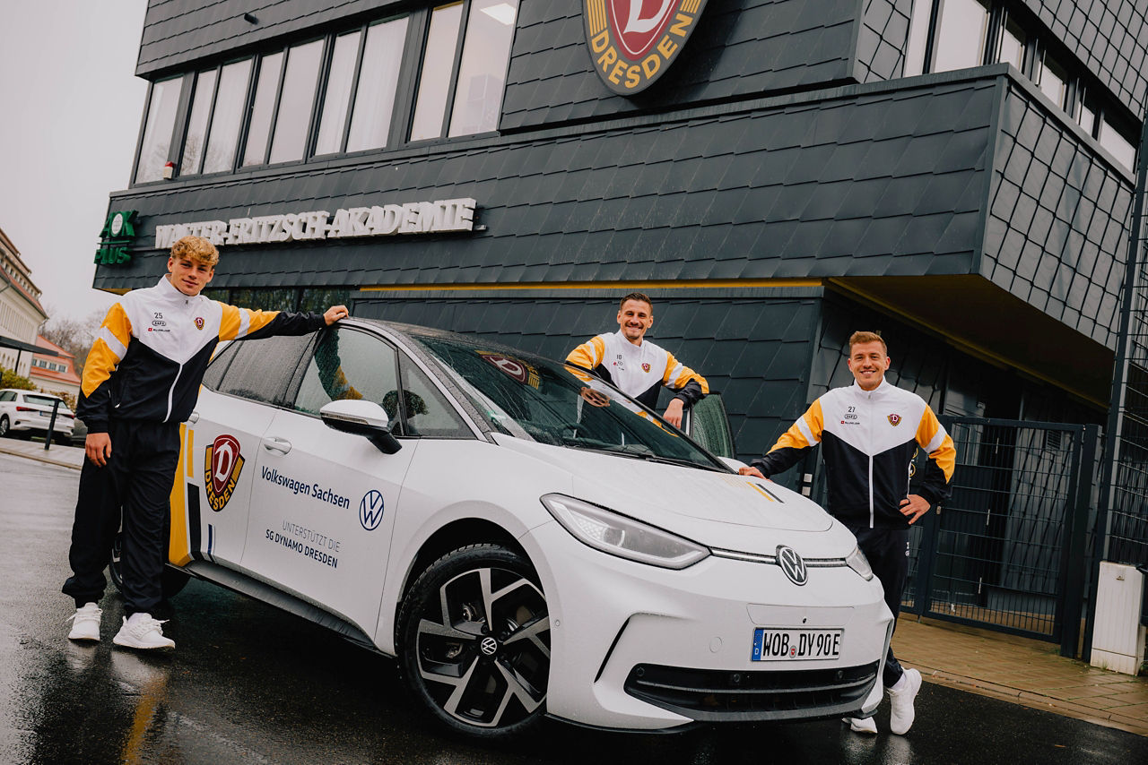 Ein weißer ID 3 mit 3 Nachwuchsspielern im Trainingszentrum von Dynamo Dresden