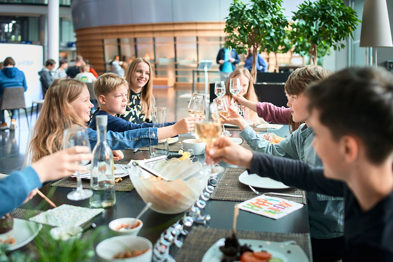 Eine Gruppe von Kindern feiert im Restaurant der Gläsernen Manufaktur Geburtstag an einem Tisch mit Getränken und Dekoration