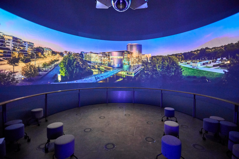 Gäste sitzen Im ID Globe und sehen sich einen Film auf der 270 Grad Leinwand an