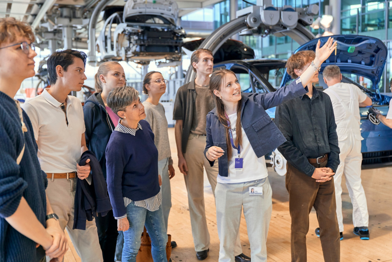 Ein Guide Führt eine Besuchergruppe durch die Fertigung der Gläsernen Manufaktur